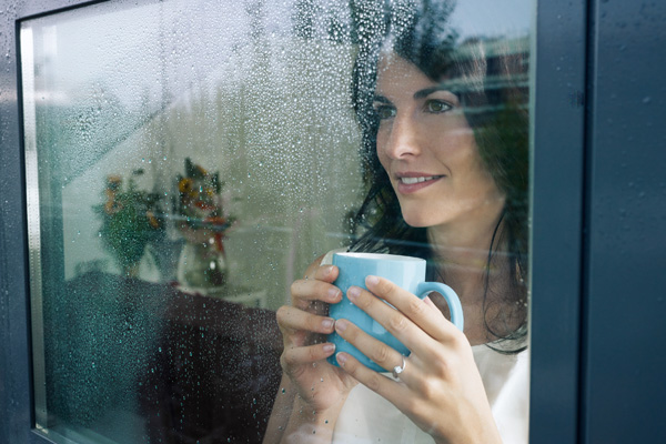 picture of warm woman standing in front of double-pane window